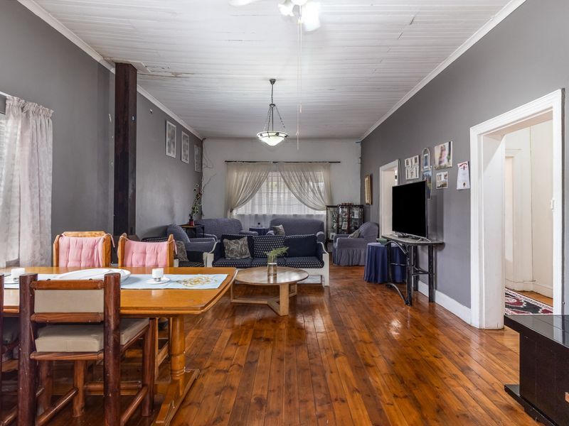 Spacious open-plan living and dining area featuring polished timber flooring and a classic timber ceiling, offering a versatile layout for family living.
