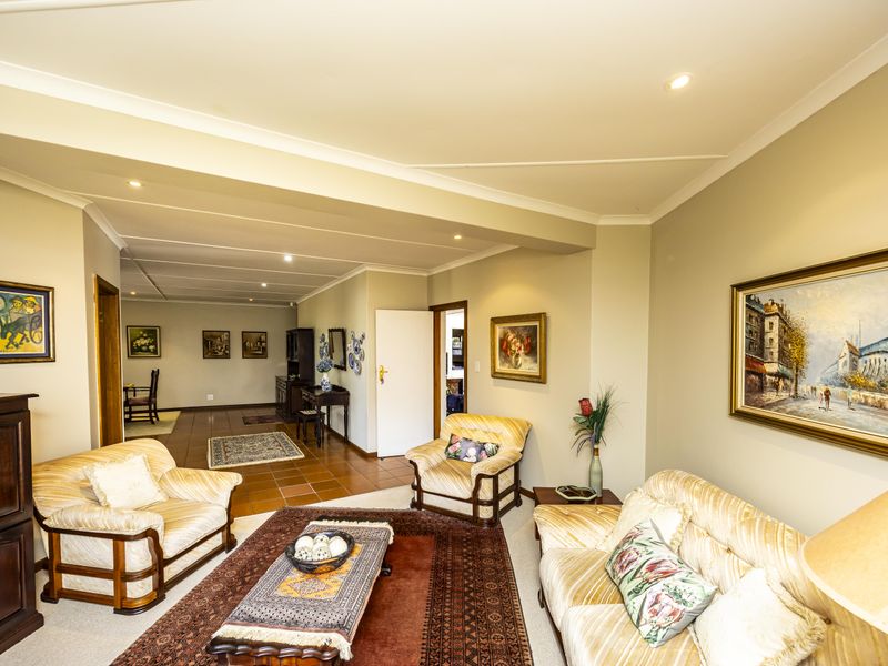 Spacious living area featuring a combination of carpet and tiled flooring, recessed downlighting, and neutral wall finishes.