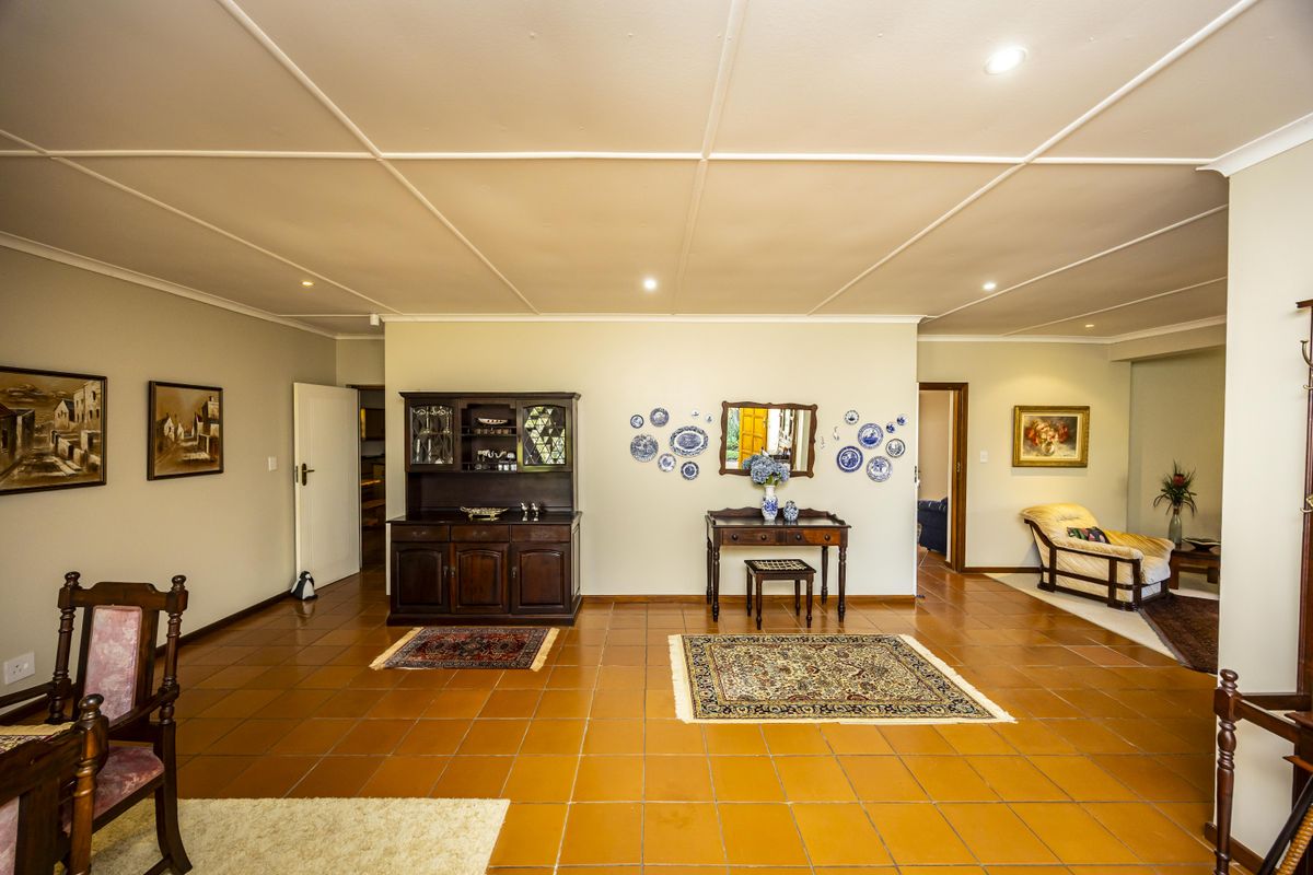 Spacious living area featuring traditional terracotta tiled flooring and a distinctive coffered ceiling with recessed lighting.