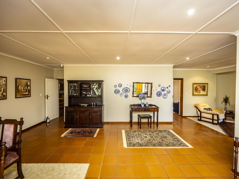 Spacious living area featuring traditional terracotta tiled flooring and a distinctive coffered ceiling with recessed lighting.