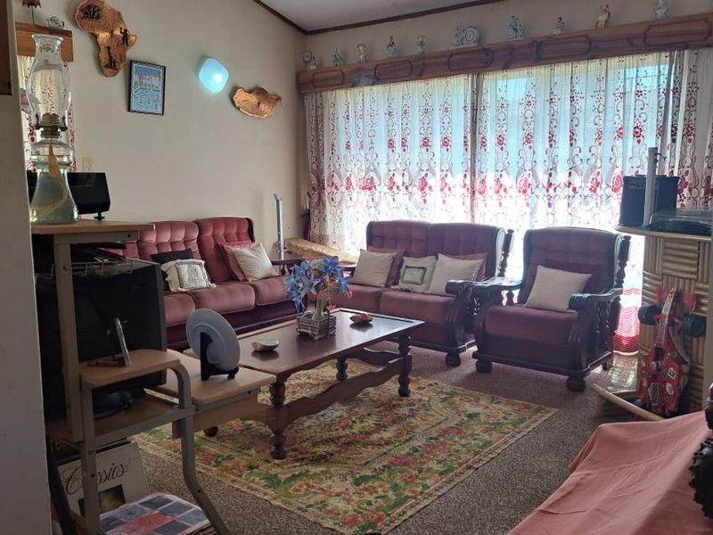 A comfortable living room featuring carpeted flooring and a large sliding glass door that provides natural light.