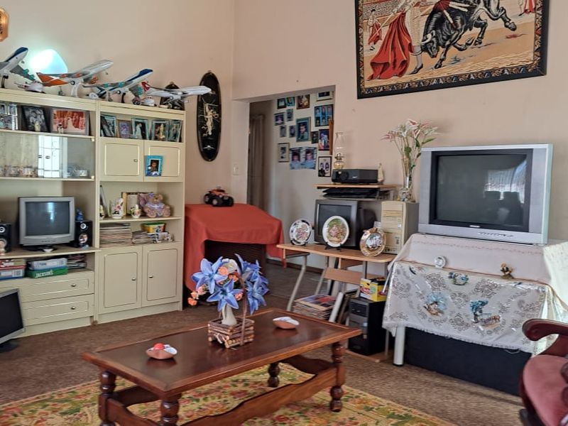 A living room area featuring carpeted flooring and access to an adjacent room, providing a functional space for relaxation.