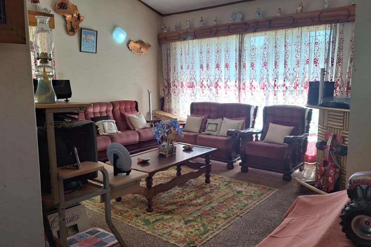 A comfortable living room featuring carpeted flooring and a large sliding glass door that provides natural light.