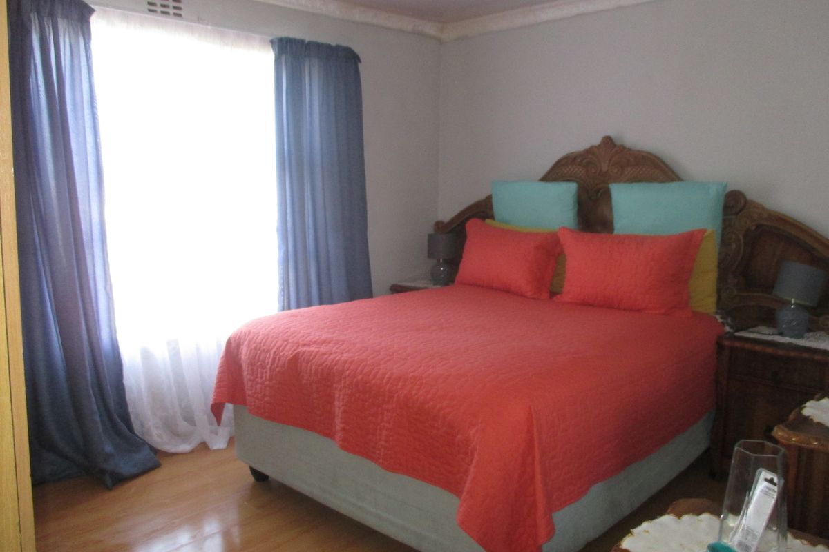 A bedroom featuring hardwood flooring and decorative ceiling cornicing, providing a neutral foundation for interior design updates.