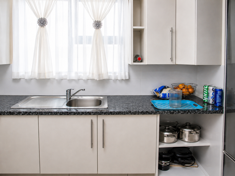 A clean and functional kitchen area featuring modern cabinetry, a stainless steel sink with mixer tap, and a durable laminate countertop.
