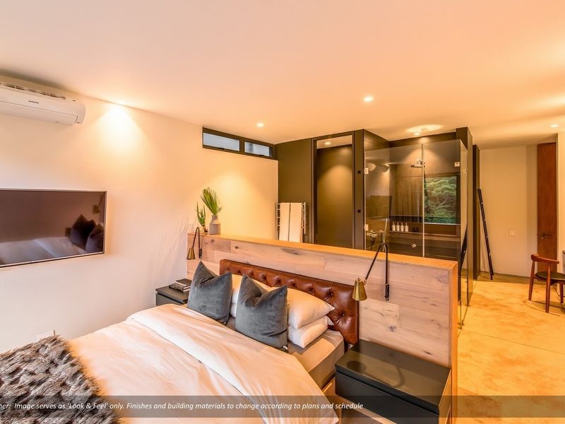 Modern bedroom featuring a timber partition headboard, integrated glass-enclosed ensuite shower, and split-system air conditioning in a contemporary open-plan layout.
