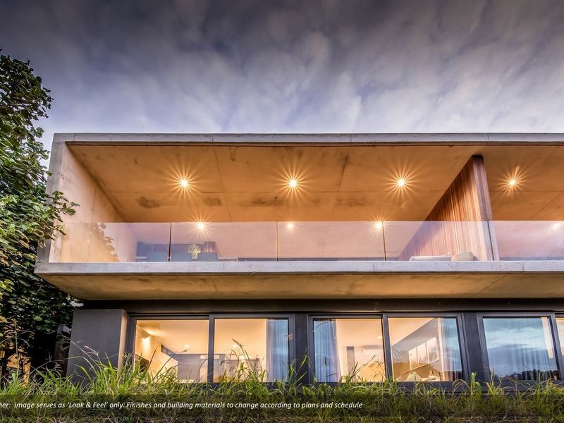 Modern townhouse rear elevation featuring a spacious concrete balcony with glass balustrades, recessed lighting, and large sliding glass doors opening to the interior.