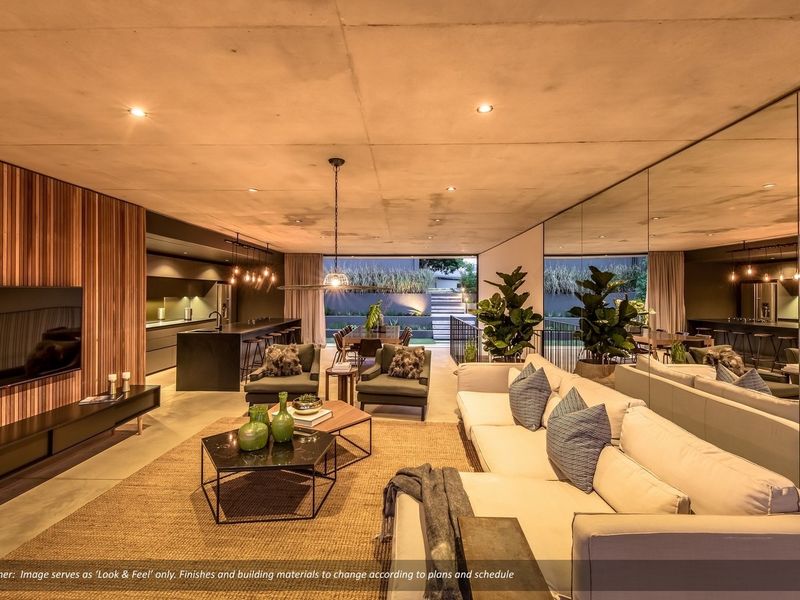 Modern open-plan living area featuring an exposed concrete ceiling, timber slat feature wall, mirrored wall, and a sleek integrated kitchen with island.