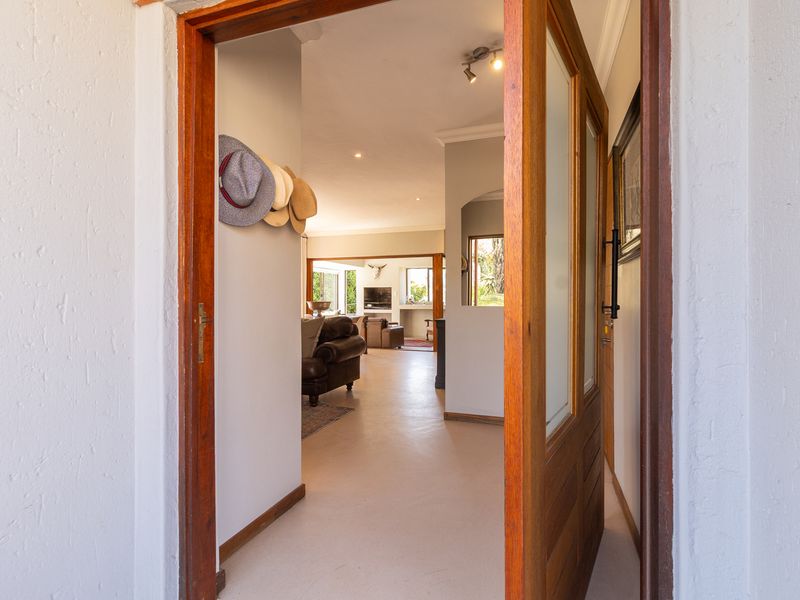 A welcoming entrance hall featuring a solid timber door and recessed lighting, providing a clear view into the open-plan living area.