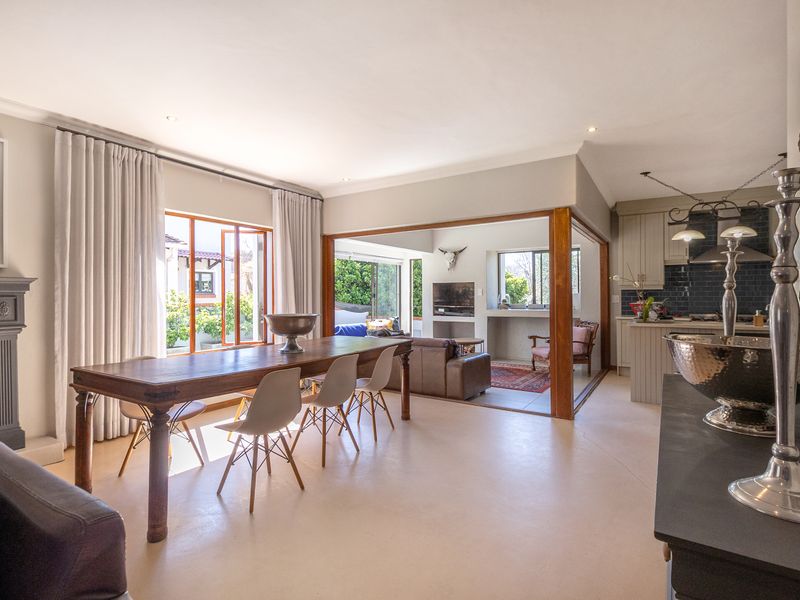 Spacious open-plan living and dining area featuring a fireplace, neutral flooring, and a seamless transition to a well-appointed kitchen with modern cabinetry.