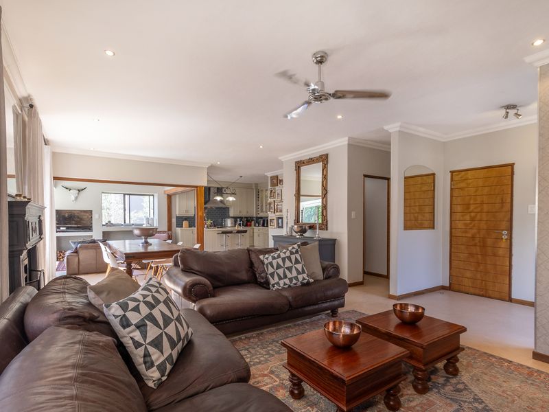 Spacious open-plan living area featuring a lounge, dining space, and kitchen with modern finishes, recessed lighting, and a ceiling fan.