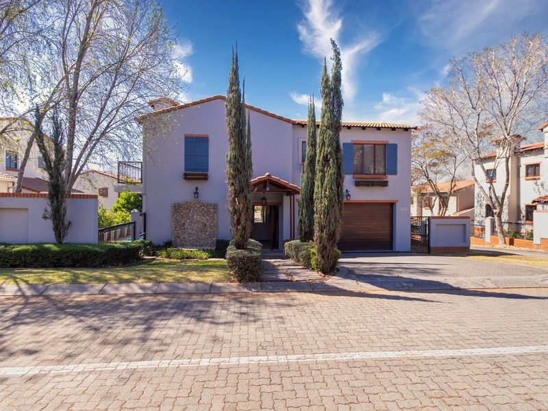 Front elevation of a two-story residential home featuring a paved driveway, integrated garage, stone accent wall, and decorative blue shutters.