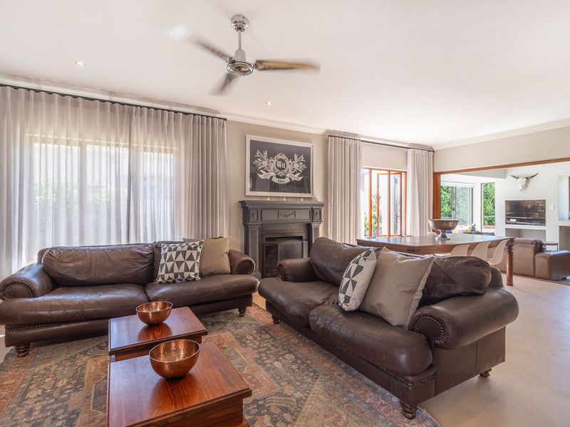 Spacious open-plan living area featuring a fireplace, ceiling fan, and large sliding glass doors that provide ample natural light and access to the outdoors.