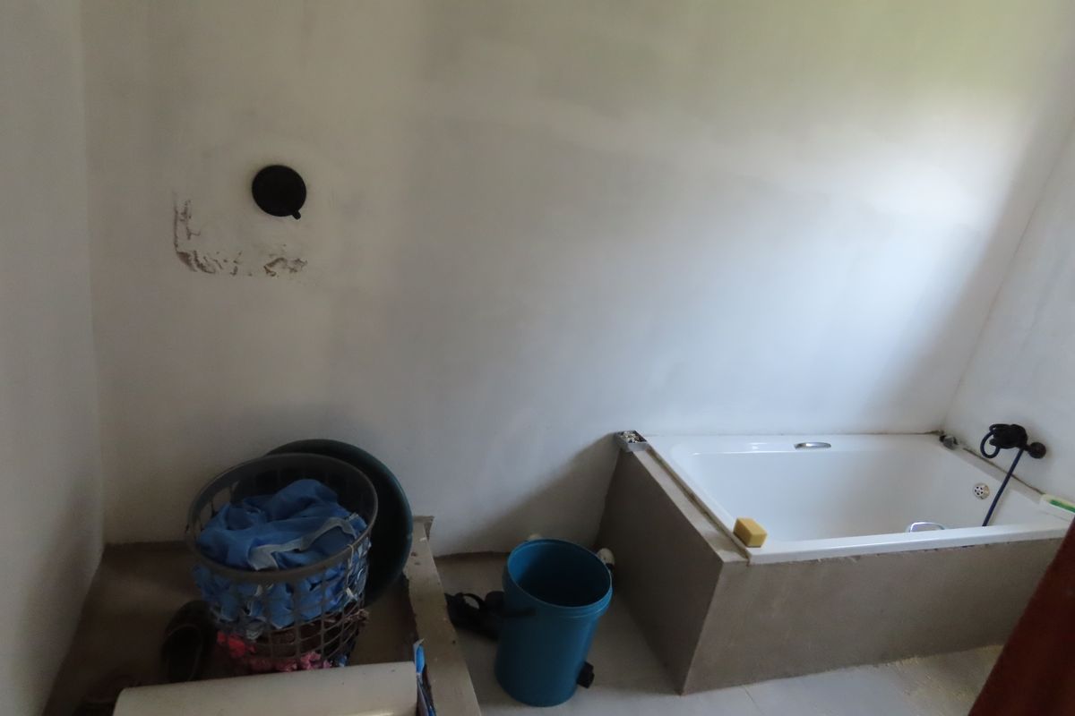 A bathroom in an unfinished state featuring a built-in bathtub and exposed wall surfaces, requiring completion and final finishes.