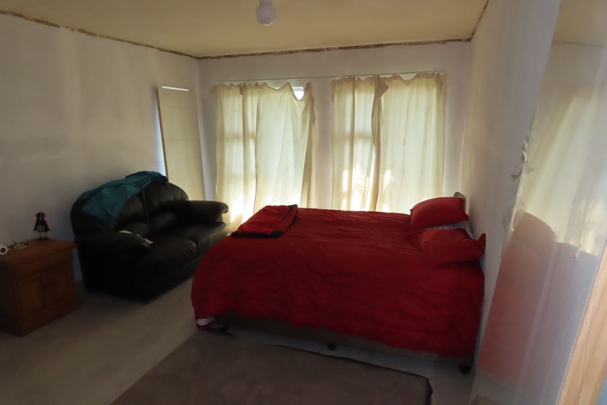 A bedroom featuring unfinished wall and ceiling edges, requiring cosmetic repairs and painting to improve the overall finish and presentation.