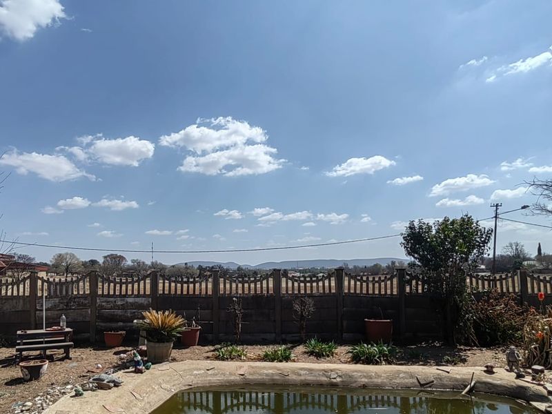 Outdoor pool area featuring a precast concrete boundary wall with views of the surrounding landscape.