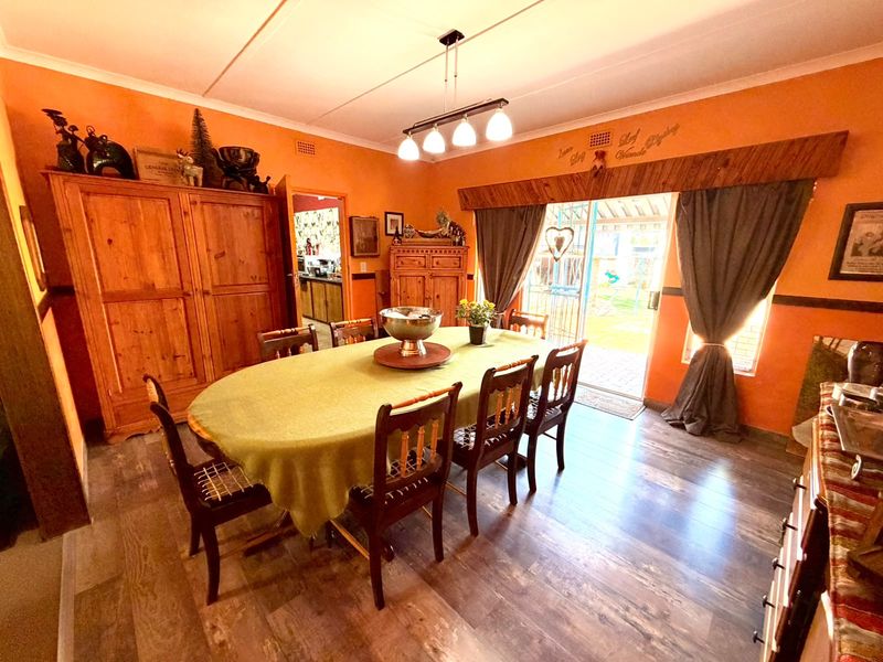 Dining room featuring laminate flooring, a sliding glass door providing garden access, and a central pendant light fixture.