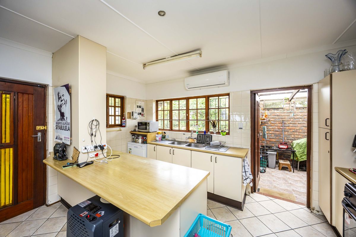 Functional kitchen featuring laminate countertops, double sink, and direct access to an outdoor courtyard area.