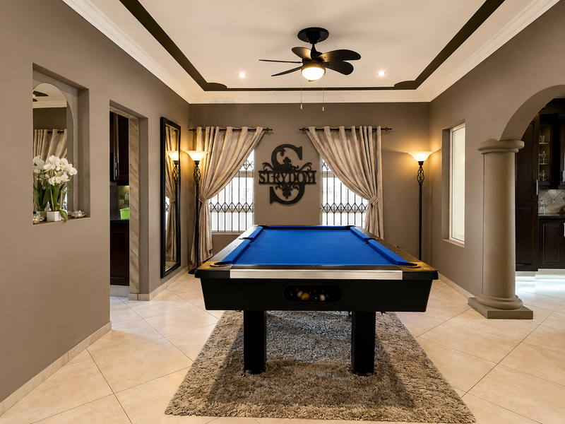 Spacious living area featuring tiled flooring, decorative archway with column, recessed lighting, and a ceiling fan, creating a well-maintained and inviting atmosphere.