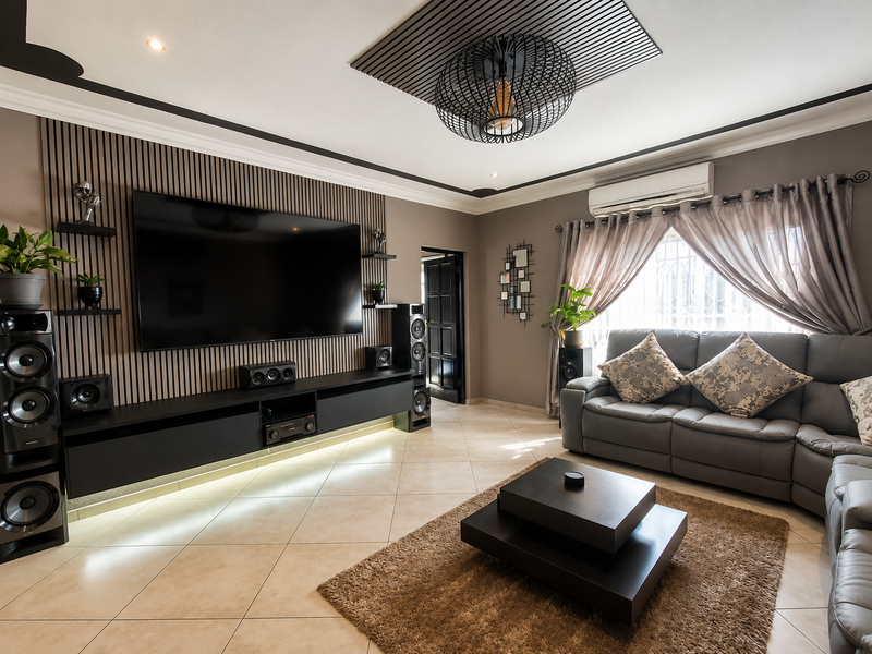 Modern living room featuring a stylish slatted timber feature wall, built-in media console with under-lighting, and a sophisticated recessed ceiling design.