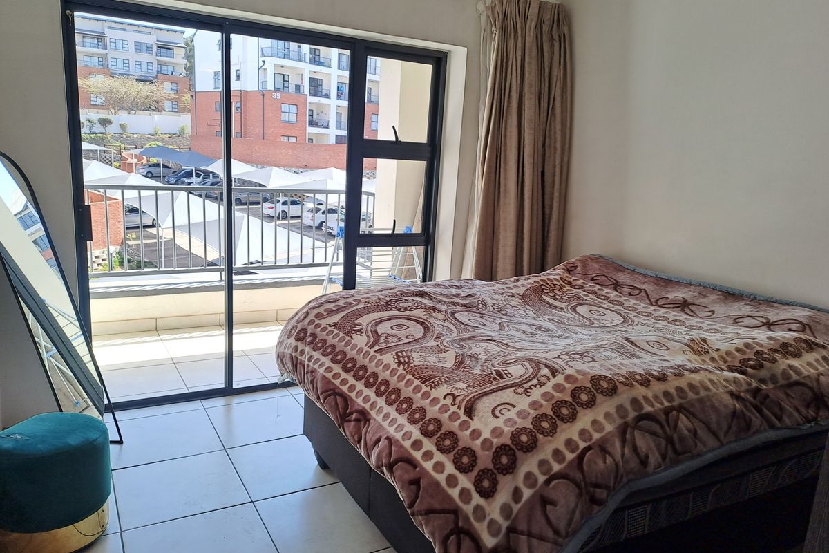 Bedroom featuring tiled flooring and a large sliding glass door providing access to a private balcony.