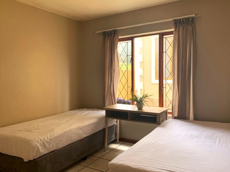 A bedroom featuring tiled flooring and a window with security bars, requiring minor cosmetic updates to improve its overall appeal.