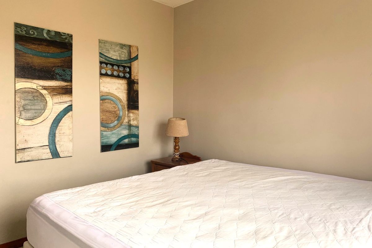 A neutrally painted bedroom featuring a simple layout, suitable for various interior design styles.