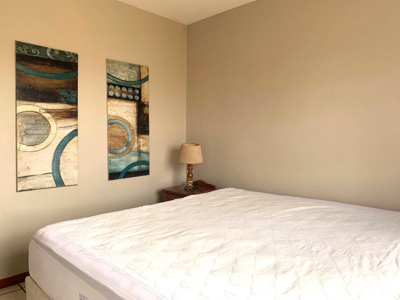 A neutrally painted bedroom featuring a simple layout, suitable for various interior design styles.
