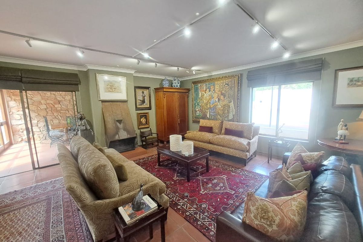 Spacious living room featuring tiled flooring, a built-in fireplace, and track lighting, with direct access to an outdoor patio area through sliding glass doors.