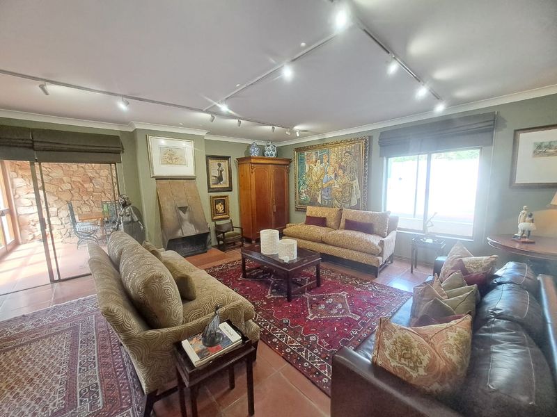 Spacious living room featuring tiled flooring, a built-in fireplace, and track lighting, with direct access to an outdoor patio area through sliding glass doors.