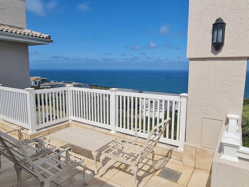 Spacious balcony featuring tiled flooring, white vinyl railings, and expansive ocean and golf course views.
