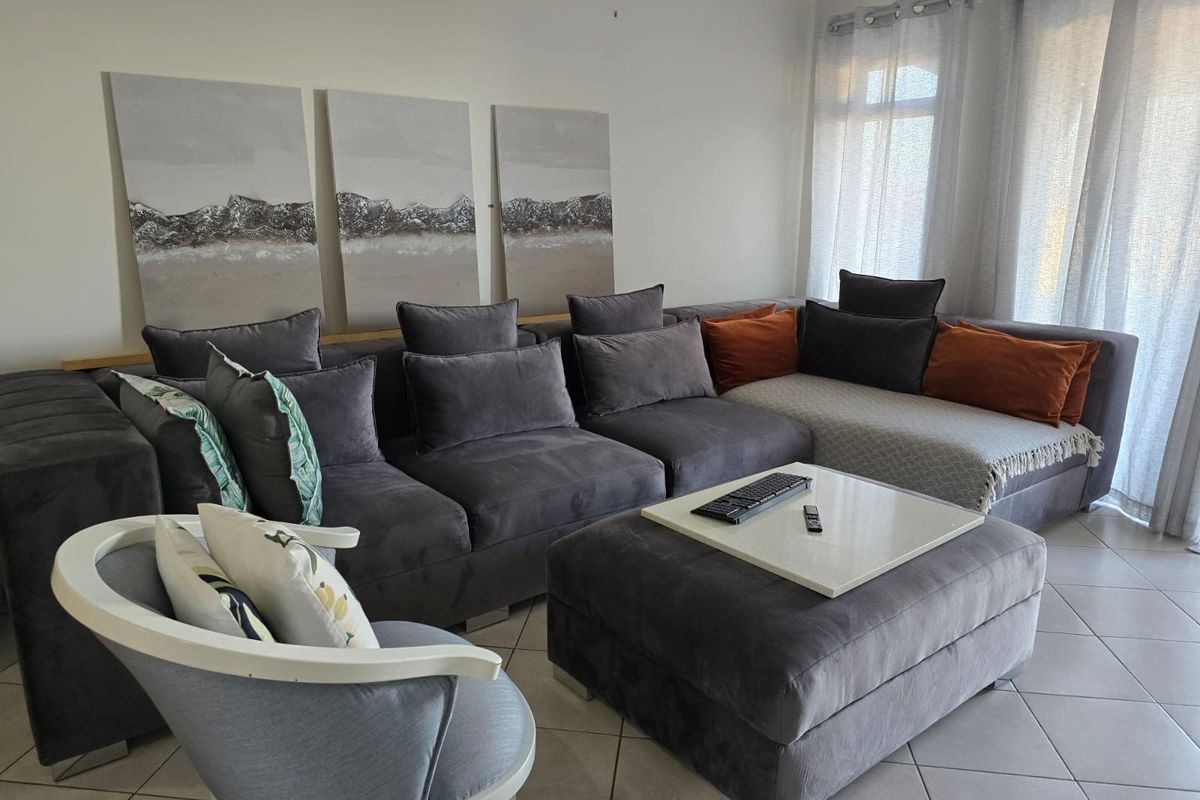 A comfortable living room featuring tiled flooring and large sliding glass doors that provide ample natural light.