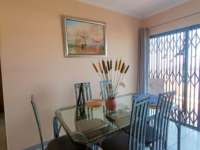 Dining area featuring tiled flooring and a sliding door with a security gate, providing access to the outdoor space.