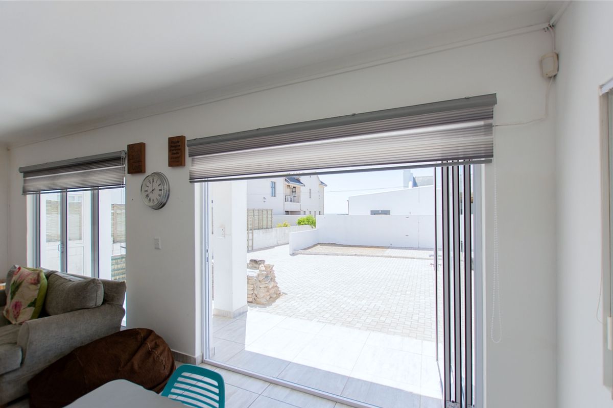 Bright living area featuring large sliding glass doors that provide seamless access to the paved outdoor patio space.