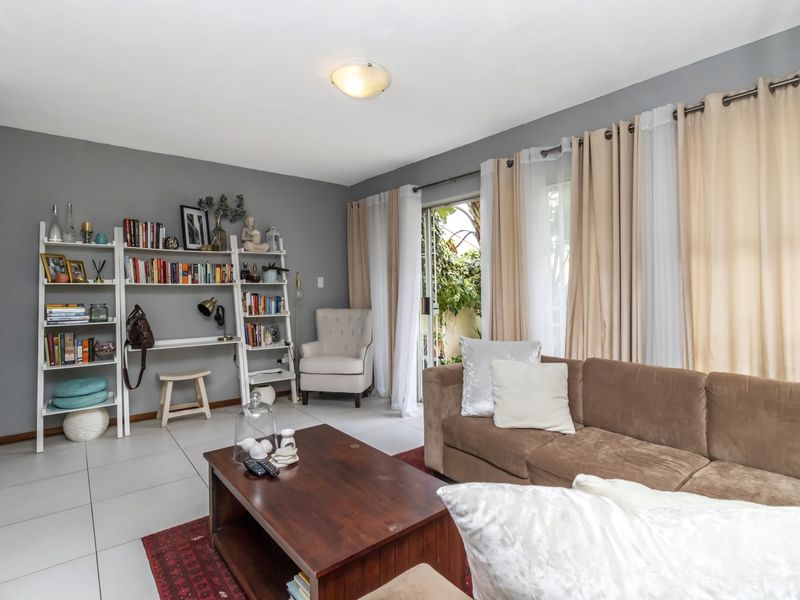 A comfortable living room featuring tiled flooring and a sliding glass door providing access to the outdoor area.
