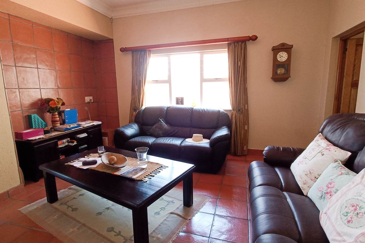 A living room featuring terracotta floor tiles and a matching tiled feature wall, providing a warm and traditional aesthetic.