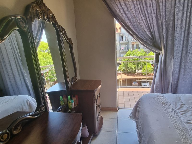A bedroom featuring tiled flooring and direct access to a private balcony through a sliding door, offering natural light and outdoor connectivity.