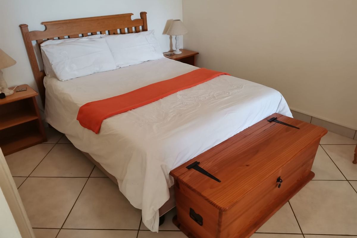 A bedroom featuring tiled flooring and neutral walls, providing a functional and comfortable sleeping space.