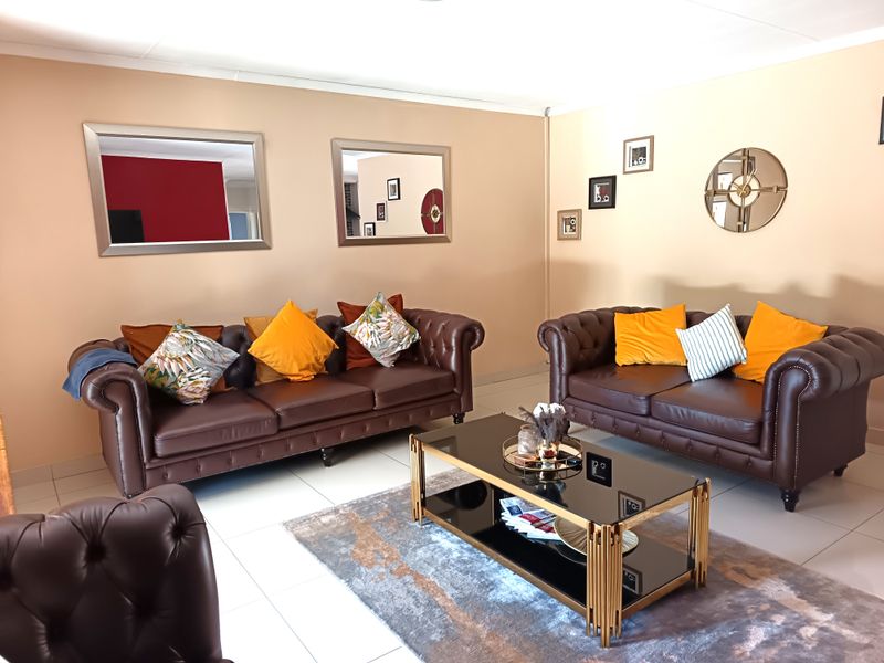 A spacious living room featuring neutral wall tones and tiled flooring, providing a comfortable and functional area for relaxation.