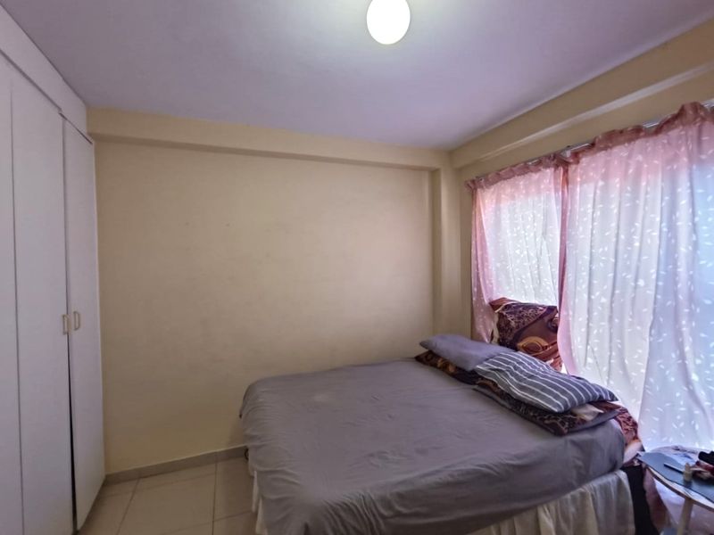 A functional bedroom featuring tiled flooring and a built-in wardrobe, offering a neutral space ready for personalization.