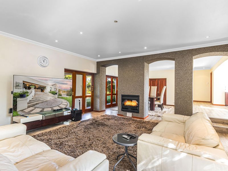 Spacious living room featuring a built-in fireplace, recessed downlighting, and arched architectural transitions leading to the dining area.