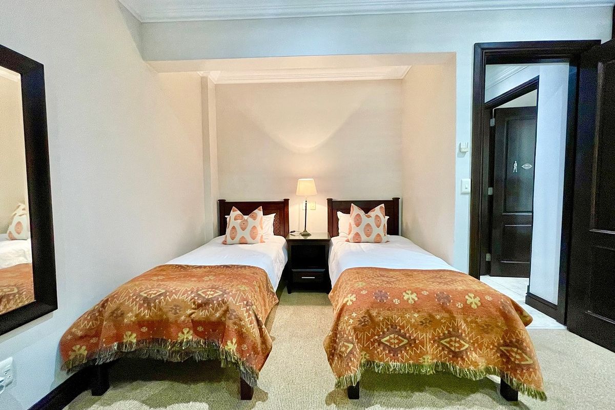 A well-maintained bedroom featuring neutral walls, carpeted flooring, and decorative cove cornicing, providing a comfortable and functional sleeping space.