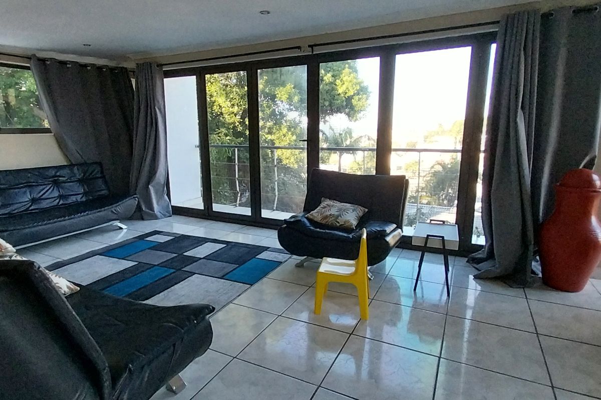 Spacious living room featuring large sliding glass doors that provide ample natural light and access to an outdoor balcony area.