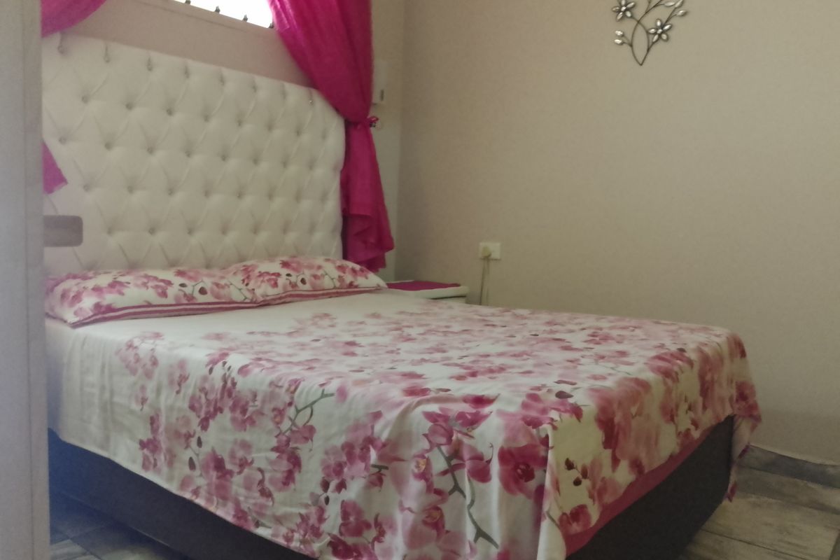 A bedroom featuring tiled flooring and a neutral wall finish.