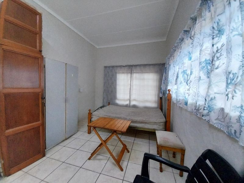 A bedroom featuring tiled flooring and a built-in cupboard, requiring cosmetic updates to improve the overall condition and appeal.