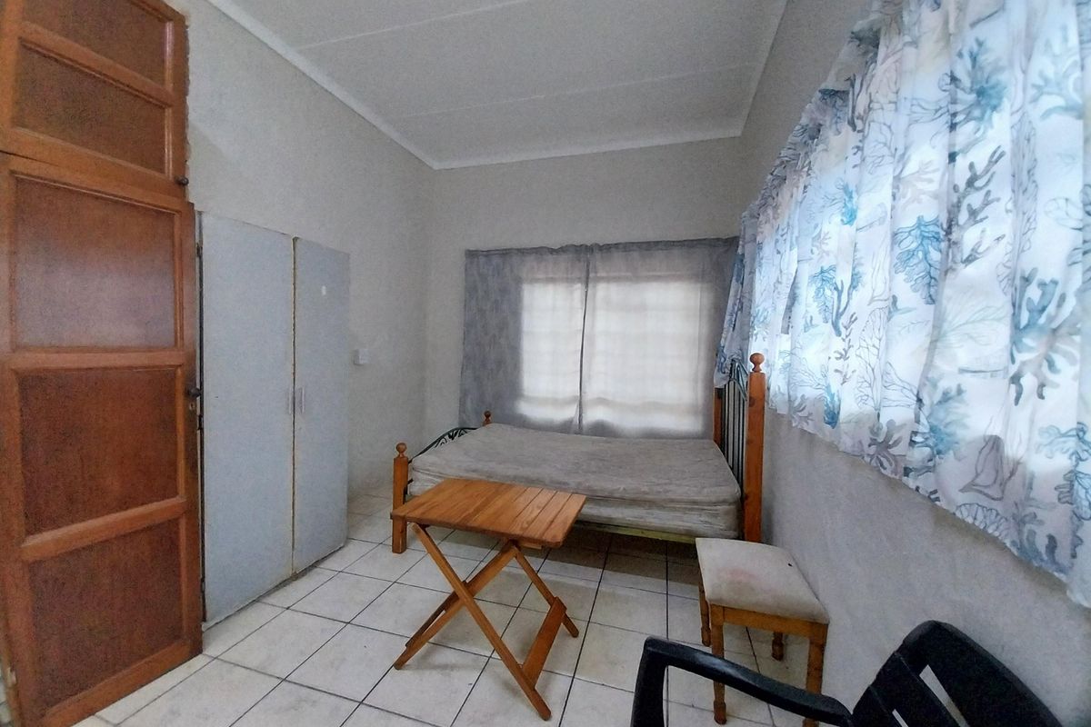 A bedroom featuring tiled flooring and a built-in cupboard, requiring cosmetic updates to improve the overall condition and appeal.