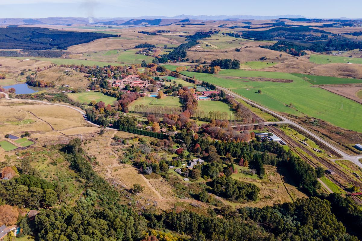 An expansive aerial view of the rural landscape, showcasing the surrounding countryside, natural vegetation, and nearby estate infrastructure.