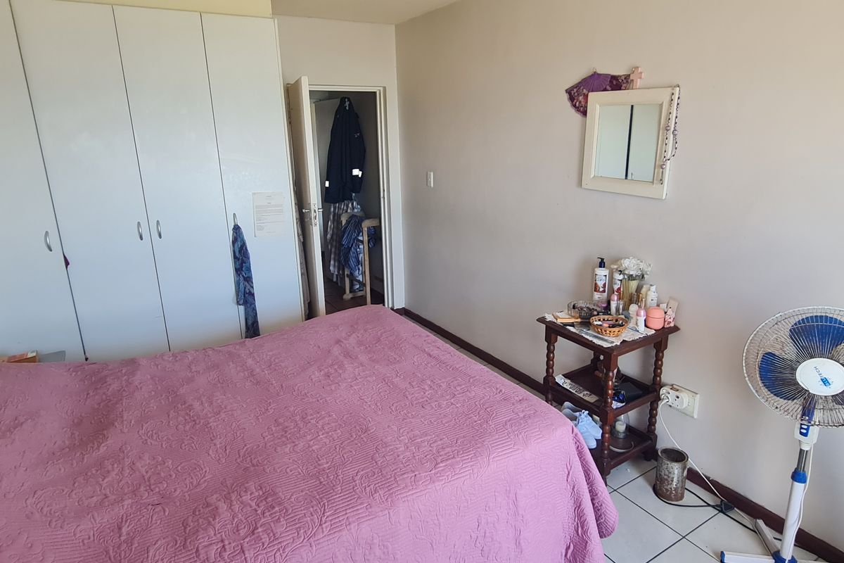 A functional bedroom featuring built-in cupboards and tiled flooring, offering a neutral base for potential interior updates.