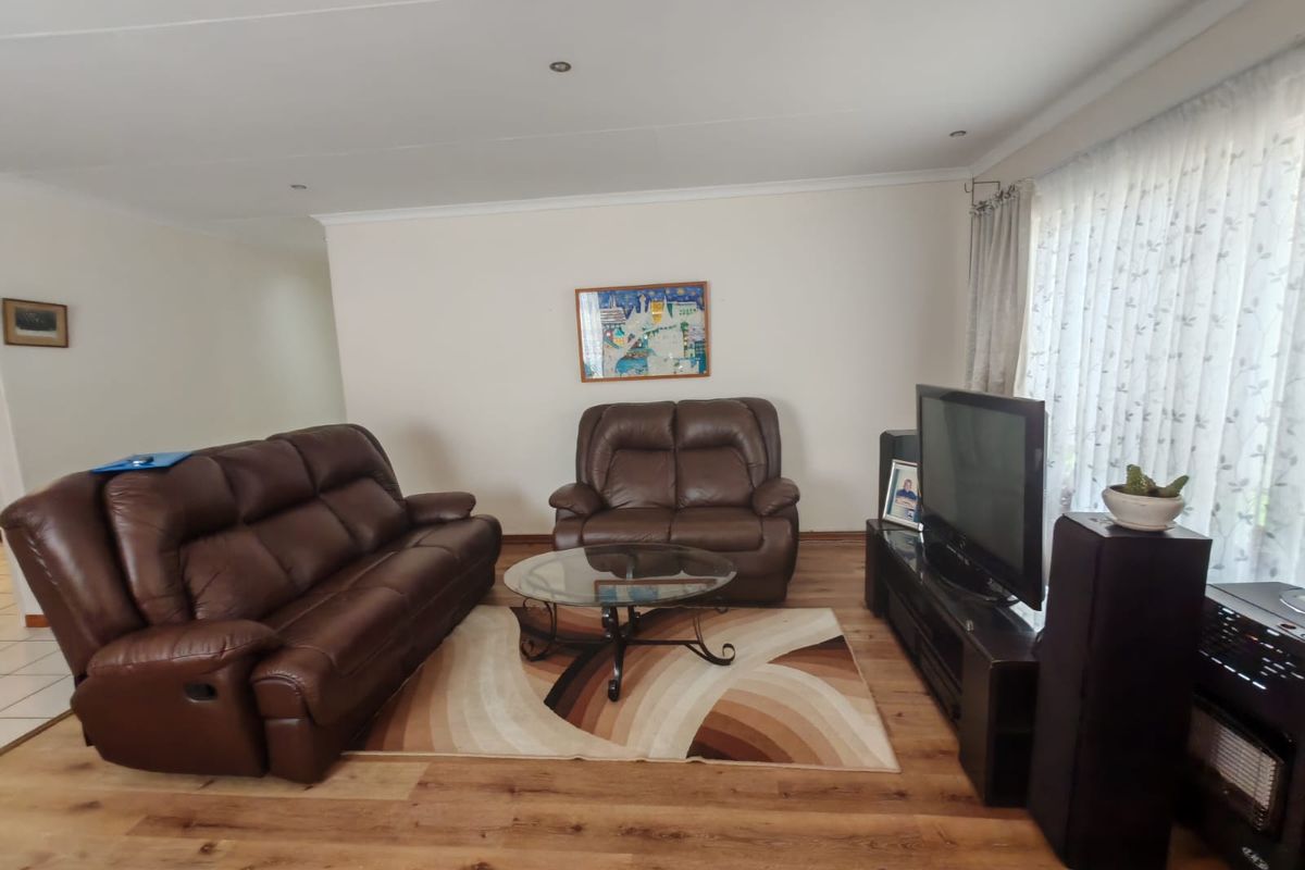A comfortable living room featuring durable laminate flooring and recessed downlighting, providing a neutral foundation for your personal interior design style.