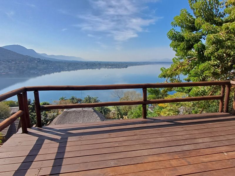 An elevated timber deck balcony offering expansive, unobstructed views of the lake and surrounding landscape.